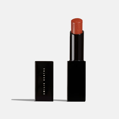 Public burnt orange shimmer lipstick product shot. Moisturizing, nourishing, hydrating, antioxidant-rich, and botanical-infused formula.
