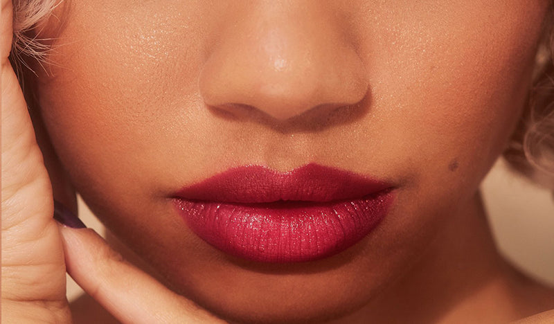 The New Vamp deep plum lipstick on model with olive skin tone. Moisturizing, nourishing, hydrating, antioxidant-rich, and botanical-infused formula.